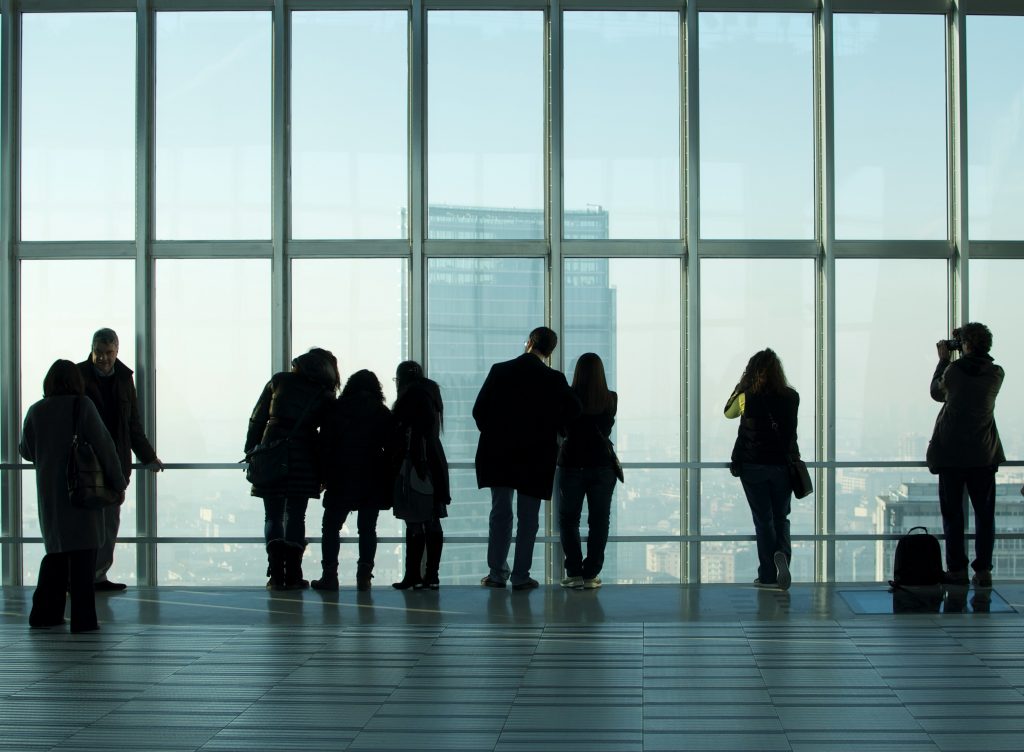 Gruppo di persone che osserva e fotografa la città dall'alto di un grattacielo